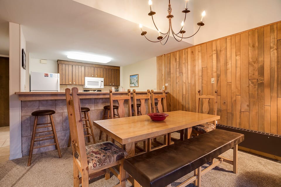 Gather around the rustic dining table where your group can share meals and memories in this cozy wood-paneled space.