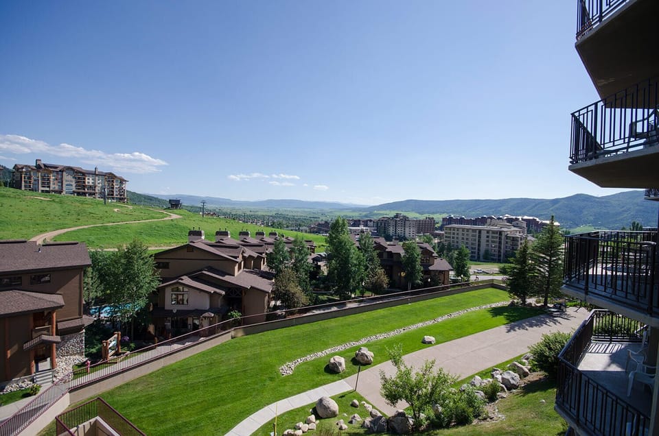 Mountain resort property with expansive valley views and manicured landscaping under clear blue skies.