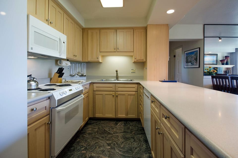 Your fully equipped kitchen features warm maple cabinetry, stainless appliances, and granite counters—perfect for preparing home-cooked meals during your stay.