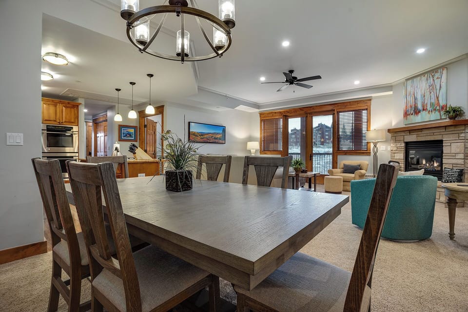Gather around your spacious dining table under warm chandelier light, where memorable meals and conversations await in this elegantly appointed open-concept space.