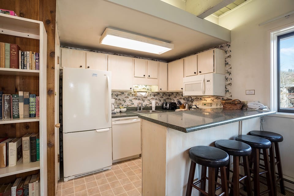 Your fully equipped kitchen features modern appliances and a breakfast bar where you can enjoy morning coffee while planning your adventures.