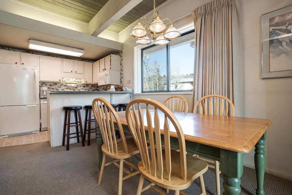 Gather around your charming farmhouse dining table where warm wood meets vintage green accents, creating the perfect spot for memorable meals.
