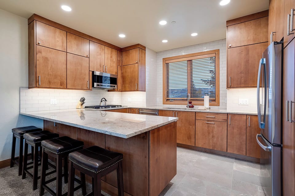 Your gourmet kitchen awaits with gleaming granite counters, rich cherry cabinetry, and stainless steel appliances—perfect for preparing memorable meals together.
