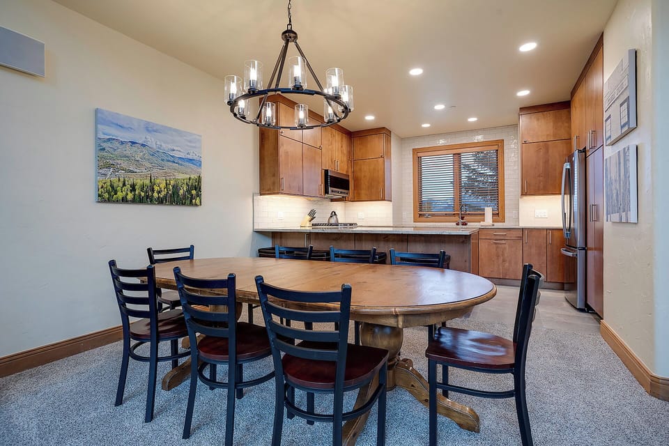 Gather around this elegant dining table where warm wood tones and mountain views create the perfect setting for your memorable meals together.