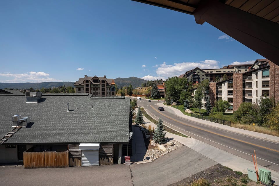 Mountain resort community with modern condominiums and convenient street access through forested hillsides.