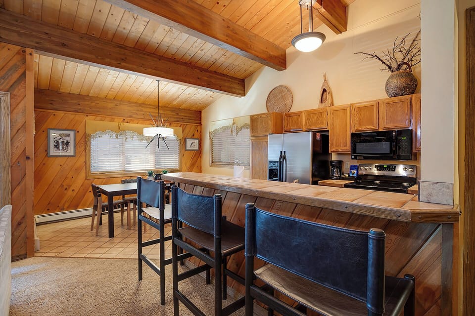 Your rustic kitchen features warm wood beams, modern appliances, and a cozy breakfast bar perfect for morning coffee or evening cocktails.