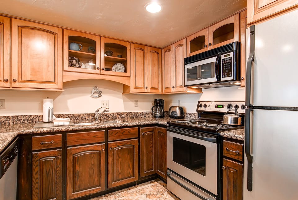 The well-equipped kitchen has wood cabinets and stainless steel appliances.