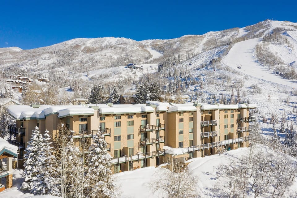 Mountain resort nestled in snow-covered slopes with ski lifts visible on the mountainside.