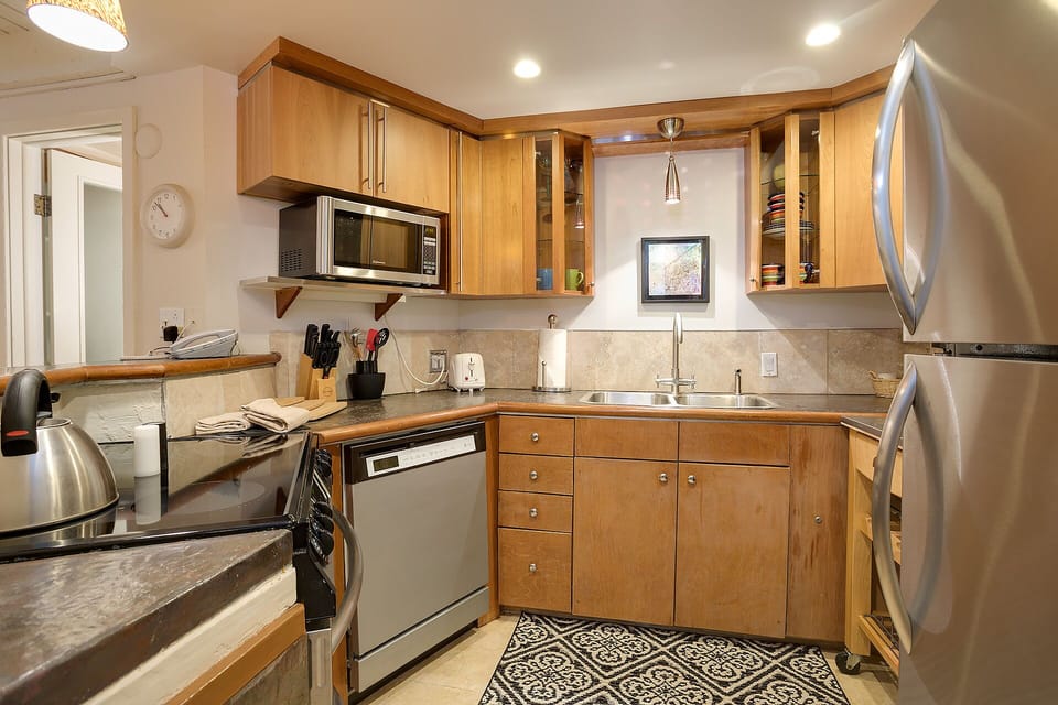 Your fully equipped kitchen features stainless appliances, granite counters, and warm wood cabinetry—perfect for preparing meals during your stay.
