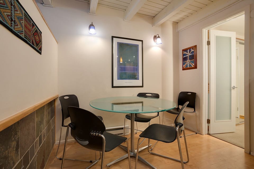 Your modern dining space features a sleek glass table surrounded by comfortable chairs, perfect for intimate meals or casual conversations.