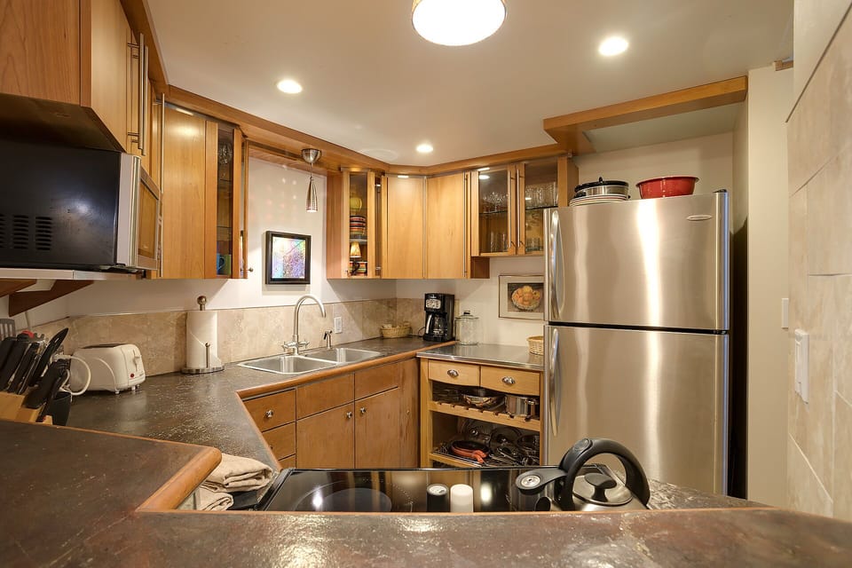 Your fully-equipped kitchen awaits with granite counters, stainless appliances, and warm wood cabinets—perfect for creating memorable meals together.