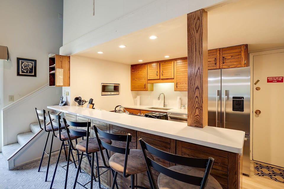 Your modern kitchen features warm wood cabinetry, stainless appliances, and a spacious breakfast bar where you can start your day.
