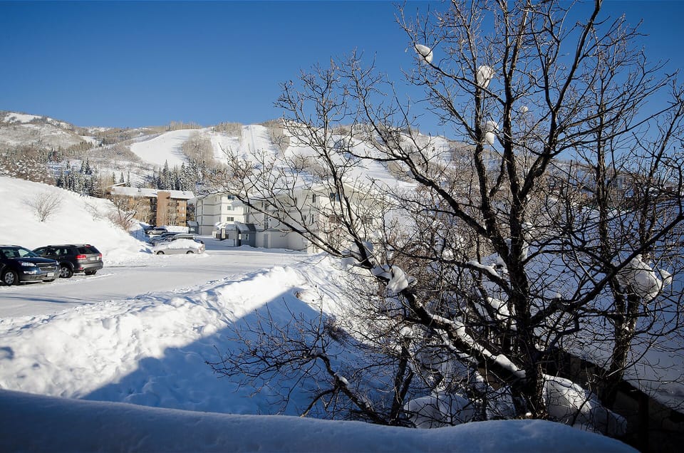 Snow-covered mountains and winter landscape surrounding the property area, with clear blue skies creating a pristine alpine setting.