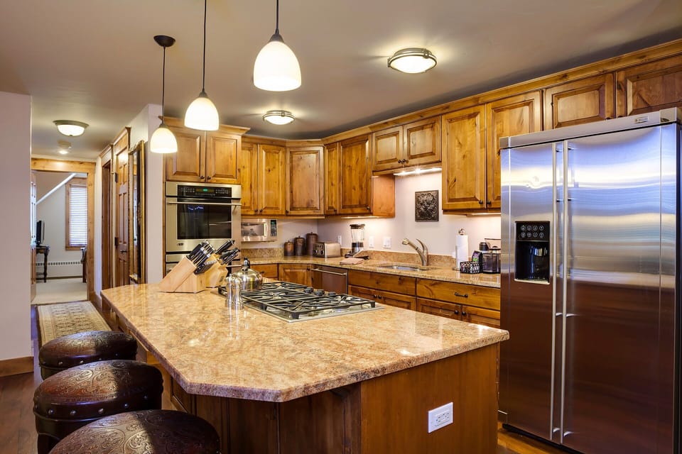 Cook memorable meals in this spacious kitchen with granite countertops, stainless steel appliances, and a welcoming breakfast bar for family gatherings.