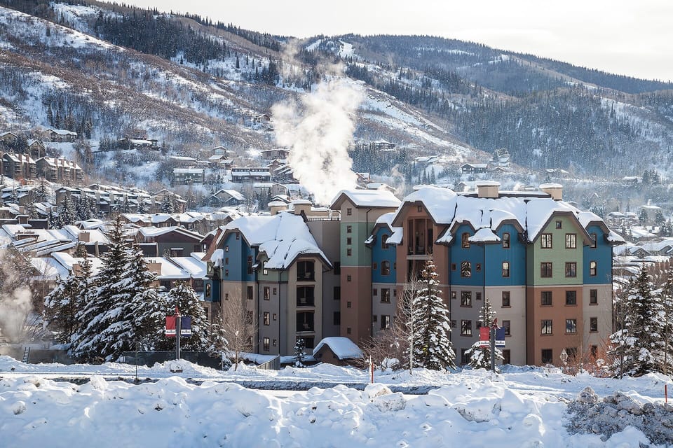 A charming mountain village nestled among snow-covered peaks, featuring colorful alpine buildings and winter scenery.