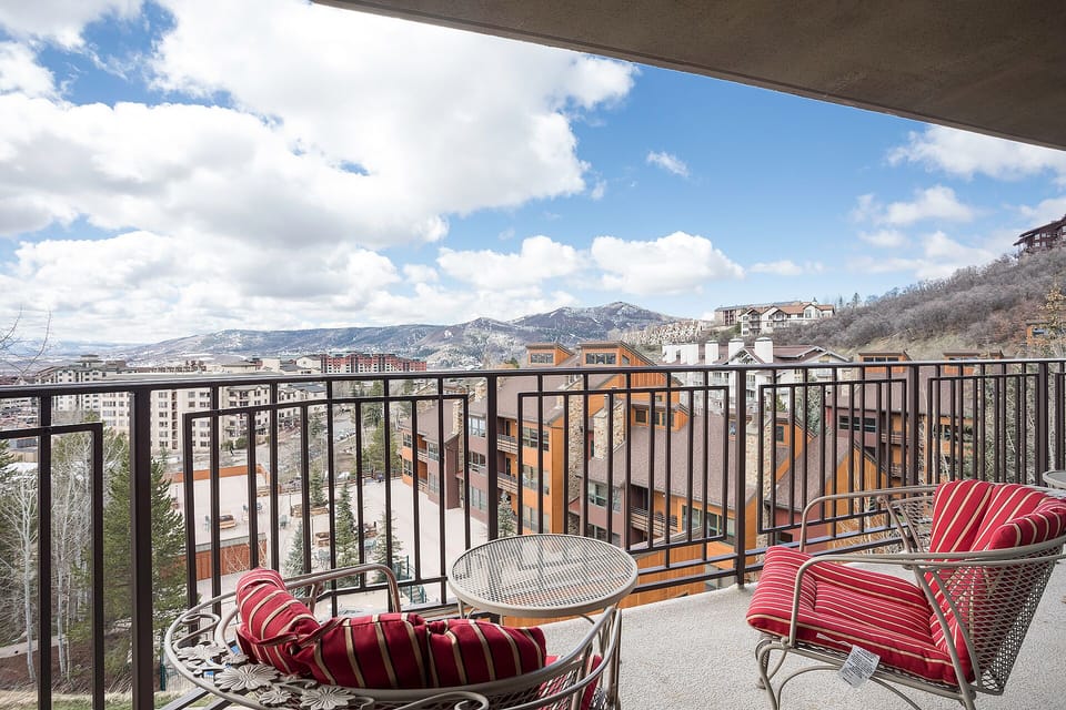 Step onto your private balcony and soak in stunning mountain views while sipping morning coffee in plush striped chairs.