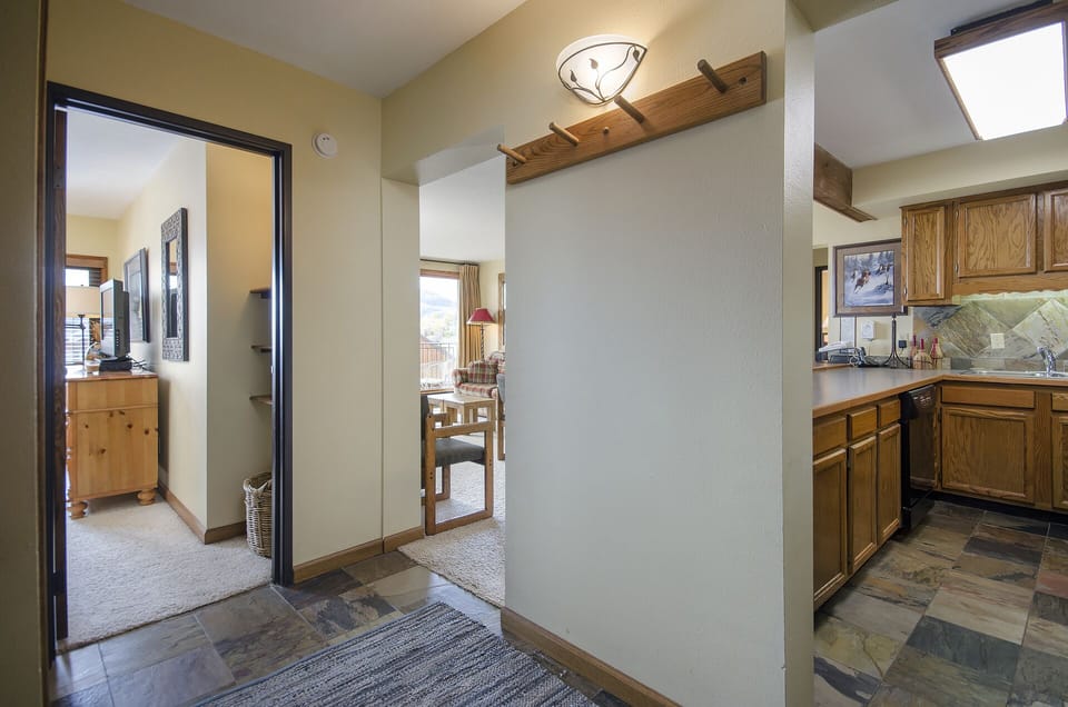 Step into your cozy mountain retreat with an open layout connecting kitchen and living spaces, featuring warm wood accents throughout.