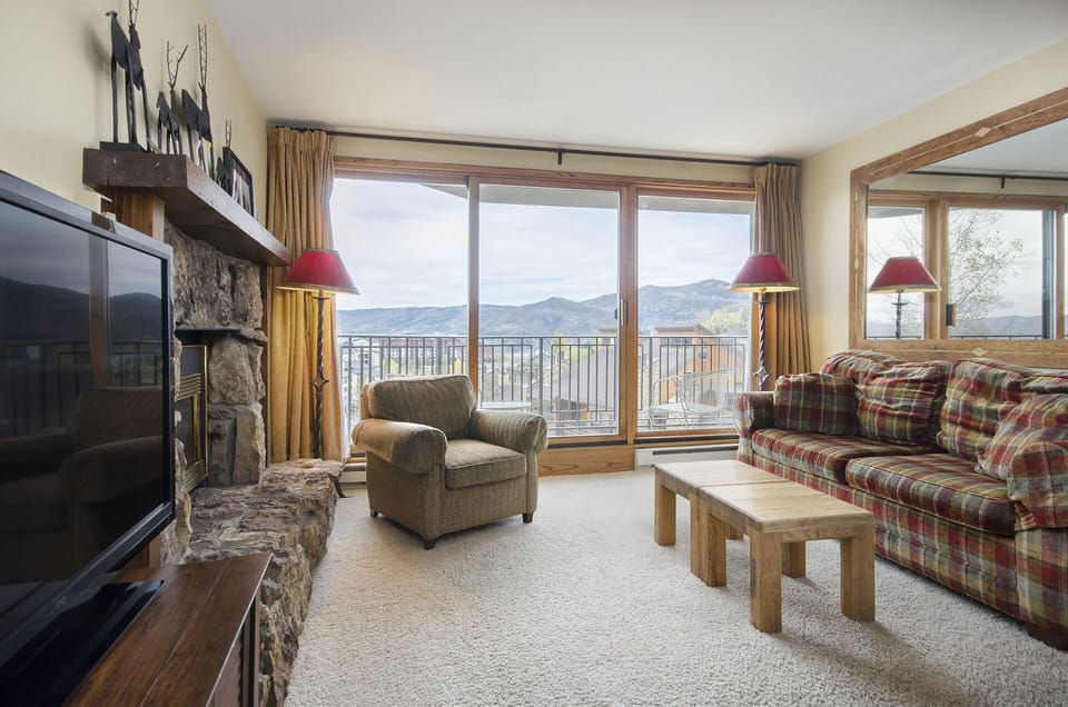 Unwind in your cozy mountain retreat with stunning panoramic views, crackling fireplace, and comfortable seating perfect for après-ski relaxation.