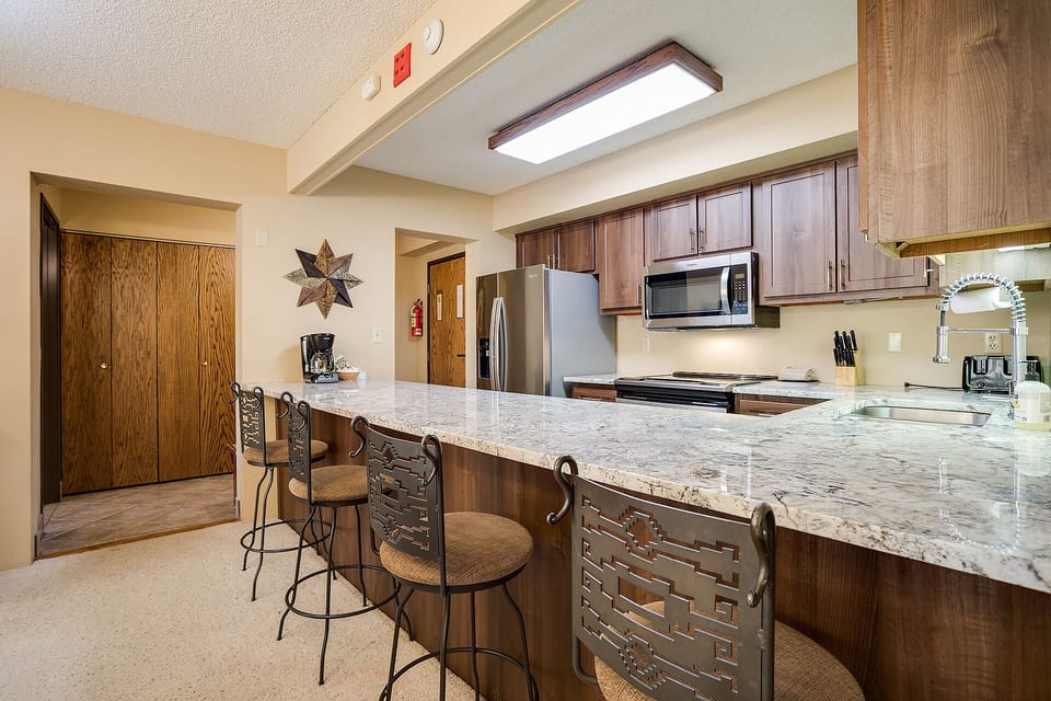 Your spacious kitchen features granite countertops, modern appliances, and a breakfast bar where you can enjoy morning coffee.