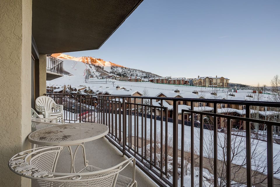 Spectacular mountain views from private balcony with ski slopes and resort buildings in view during winter season.