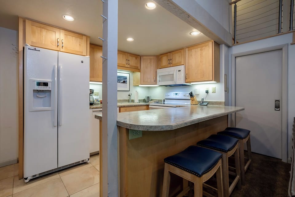 Your modern kitchen features granite counters, breakfast bar seating, and full appliances for preparing delicious meals during your stay.