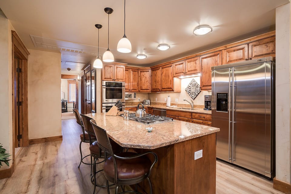 Your gourmet kitchen features warm wood cabinetry, granite countertops, and stainless steel appliances—perfect for creating memorable meals during your stay.