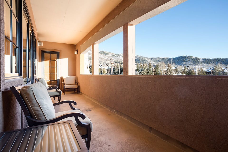 Relax on your private balcony with comfortable seating and stunning mountain views stretching across the snowy landscape.