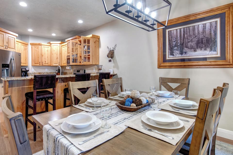 Gather around this inviting dining table where your group can share meals and stories, with a fully equipped kitchen ready for your culinary adventures and warm mountain-inspired décor setting the perfect cozy tone.