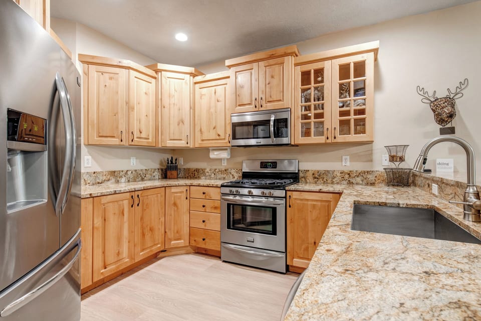 Your spacious kitchen features warm wood cabinetry, gleaming granite countertops, and modern stainless steel appliances—perfect for preparing meals during your mountain getaway.