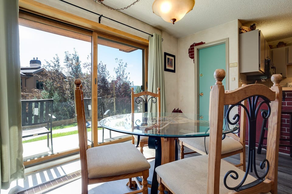 Your elegant dining space features a glass-top table with ornate wooden chairs, perfect for morning coffee while enjoying garden views through the sliding doors.