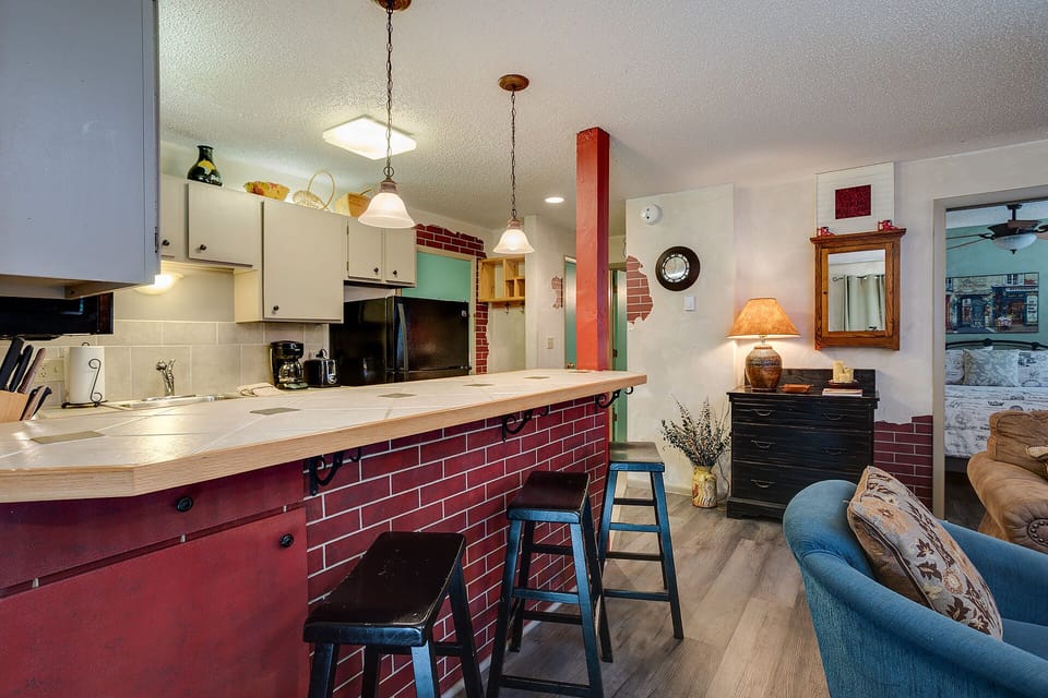 Your charming open-concept space features a striking red brick breakfast bar where you can enjoy morning coffee while planning adventures.