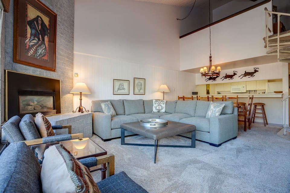 Unwind in your spacious living area with a cozy sectional sofa and warm fireplace, perfect for relaxing after mountain adventures.