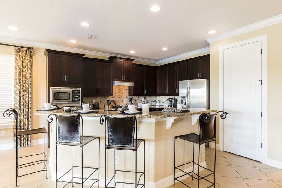 The fully-equipped kitchen features stainless steel appliances and a breakfast bar with seating for 4