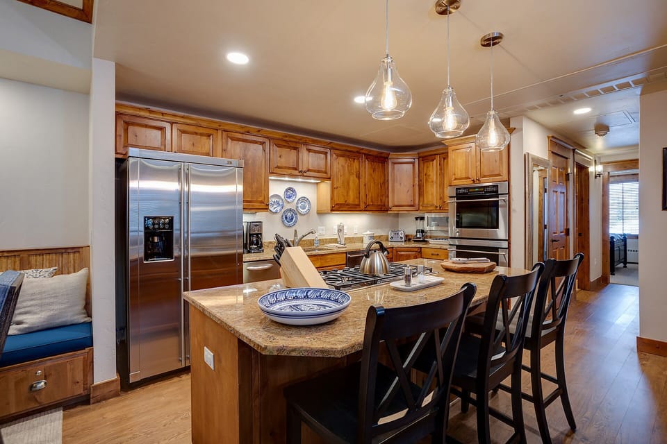 Your gourmet kitchen invites culinary adventures with granite countertops, stainless steel appliances, and elegant pendant lighting creating the perfect cooking atmosphere.