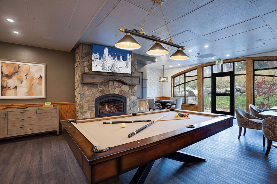 Challenge friends to pool while the fireplace crackles nearby. This elegant game room creates perfect moments for friendly competition.