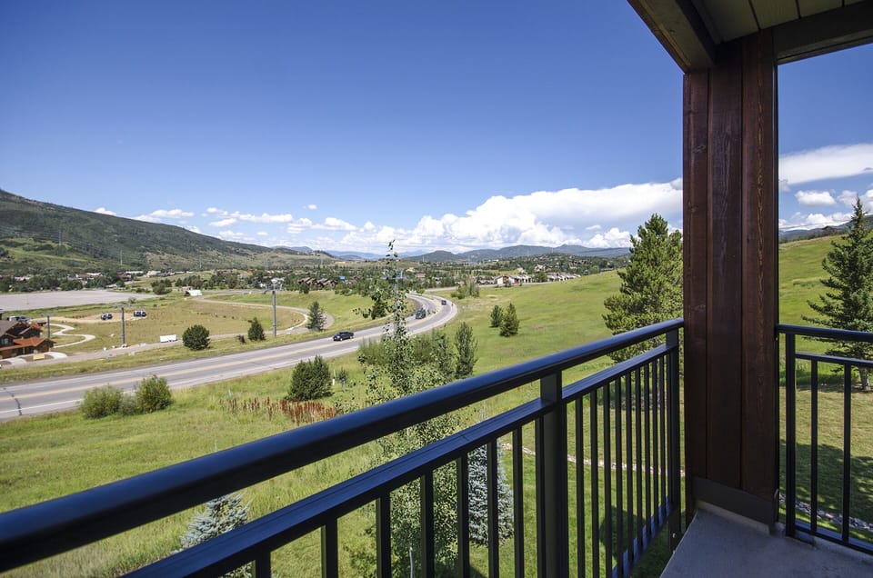 Expansive mountain and valley views stretch across rolling green fields from this elevated balcony overlooking the scenic countryside.