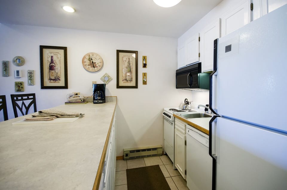 Cook your favorite meals in this well-equipped kitchen featuring modern appliances and charming wine-themed décor that adds personality to your culinary adventures.