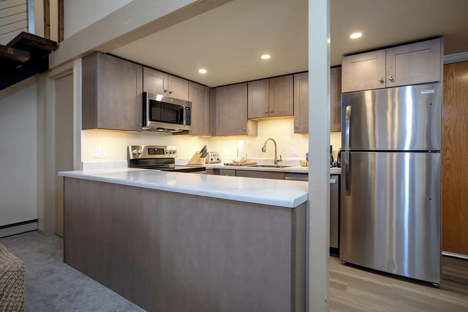 Your modern kitchen features sleek cabinetry, stainless appliances, and a spacious island perfect for preparing meals and gathering together.