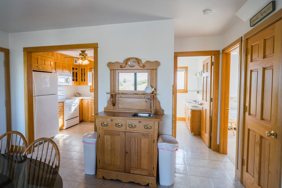 View of wet bar, dining table, kitchen, main bath, closet, & bedroom 3 entrance.