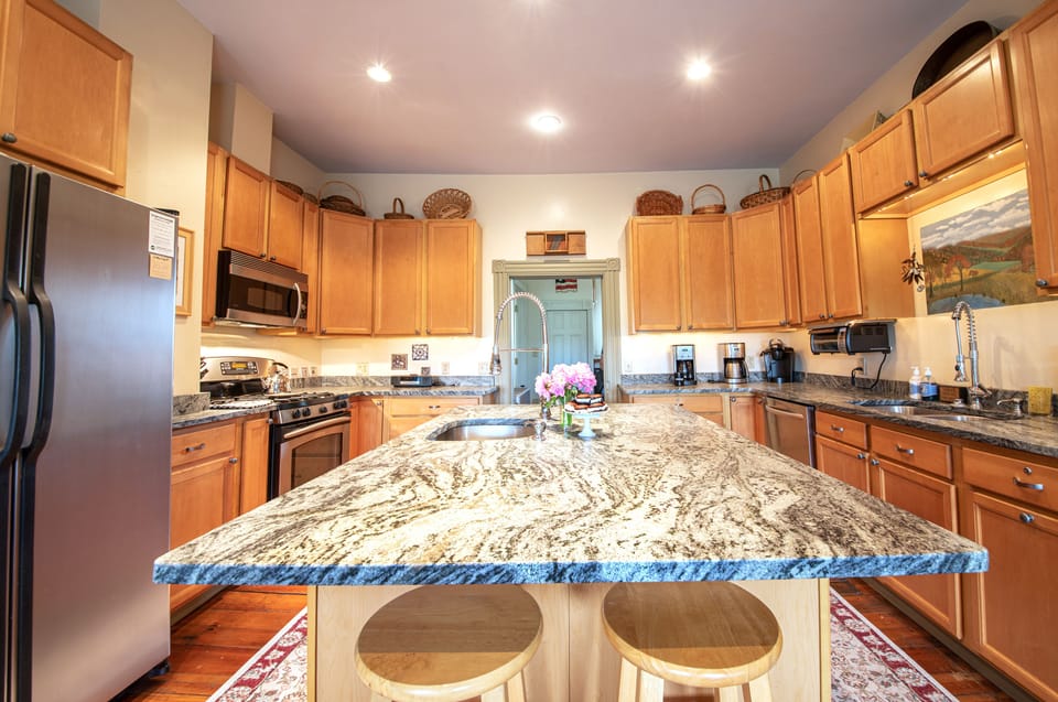Granite counters, stainless steel appliances, gas range, dishwasher, two sinks.