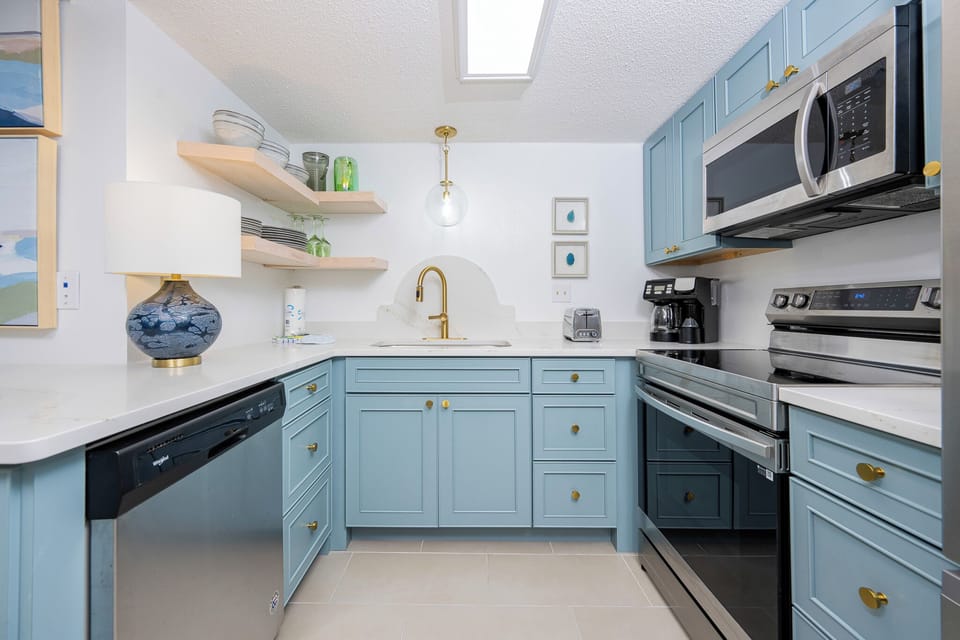 The kitchen features light blue cabinets, stainless appliances, and elegant decor, perfect for dining or entertaining
