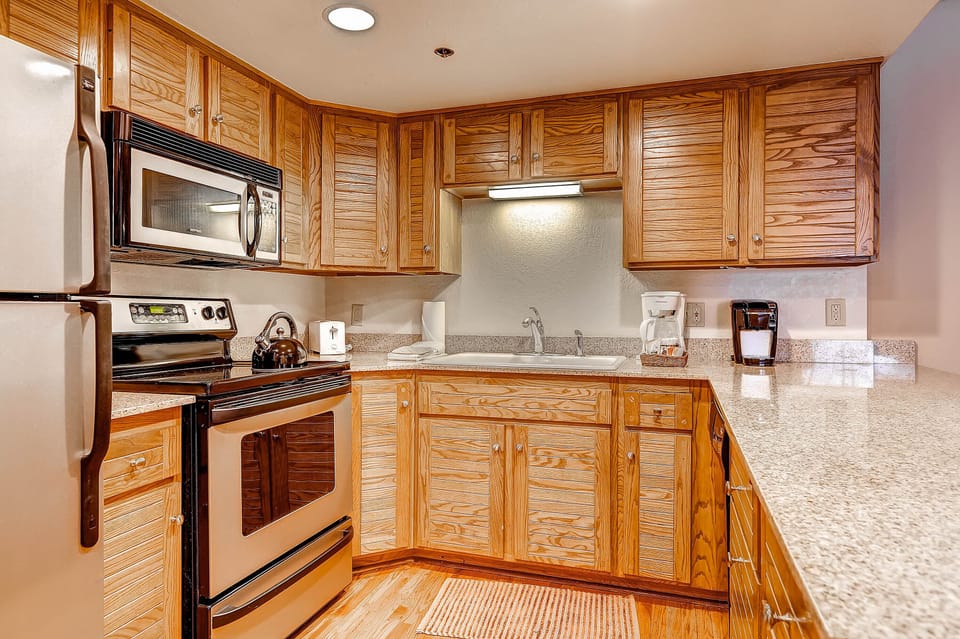 The well-equipped kitchen offers stainless steel appliances and wood cabinets.