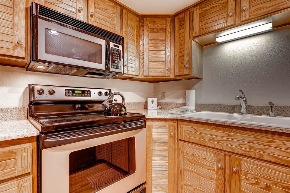 The well-equipped kitchen offers stainless steel appliances and wood cabinets.