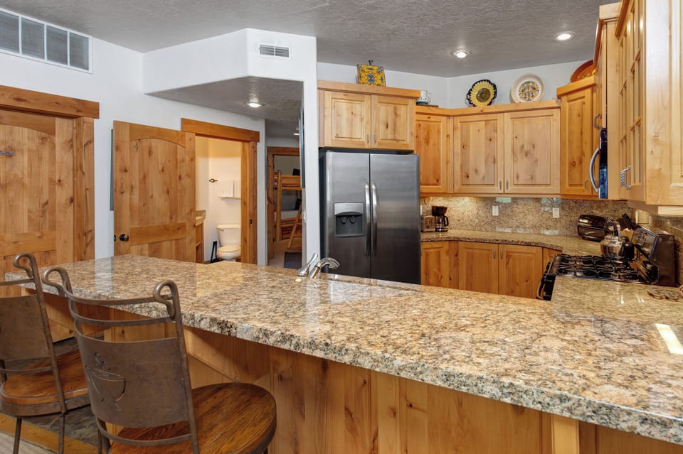 The well-equipped kitchen offers a breakfast bar with seating for 2.