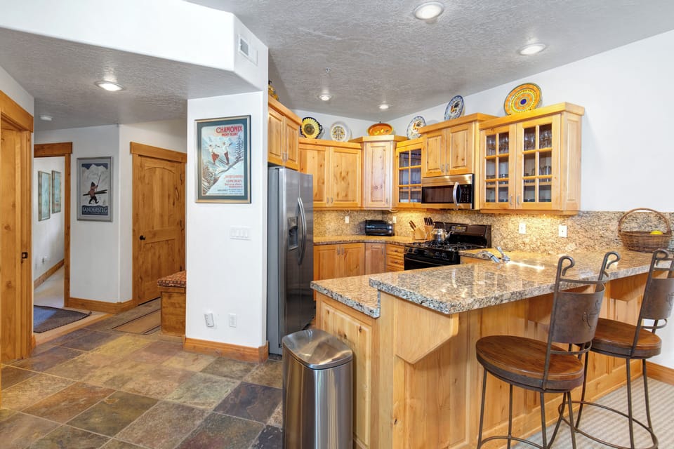 The well-equipped kitchen offers solid wood cabinets, granite counters and spacious floor plan.