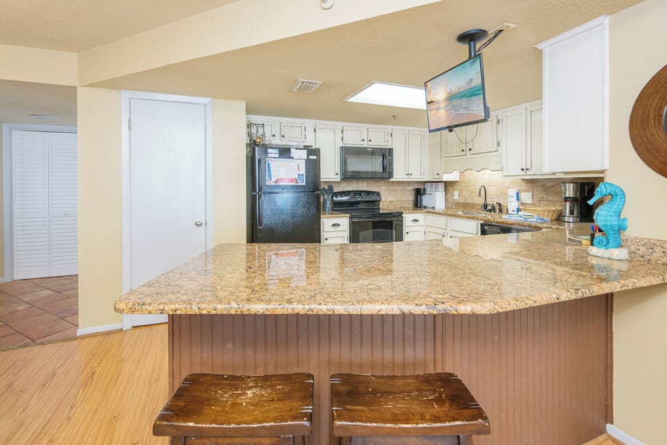 Fully-equipped kitchen features stylish countertops, a breakfast bar, and a kitchen TV to enhance your culinary experience