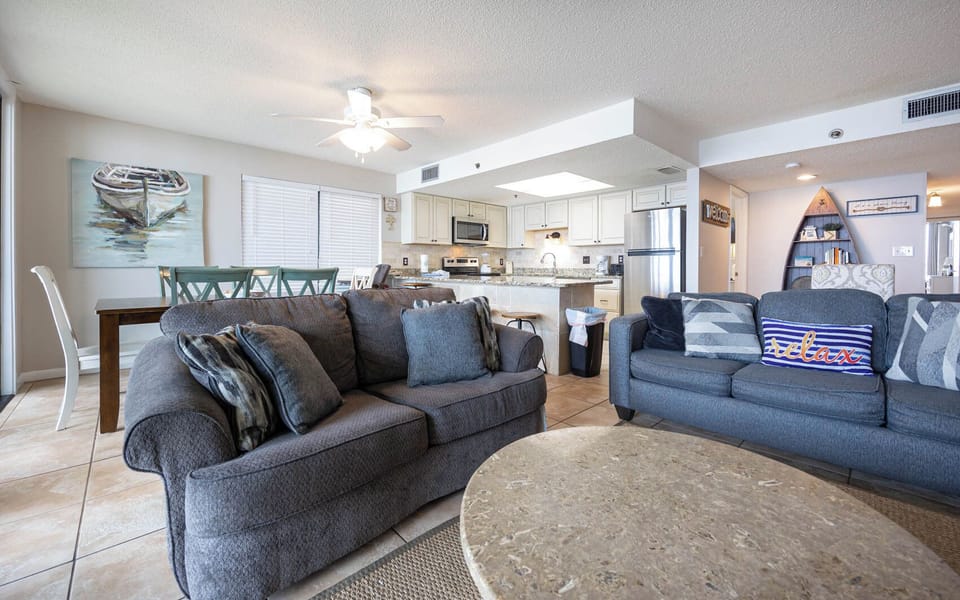 The living area features a cozy couch with queen sleeper, a stylish coffee table, and a dining space for relaxing gatherings