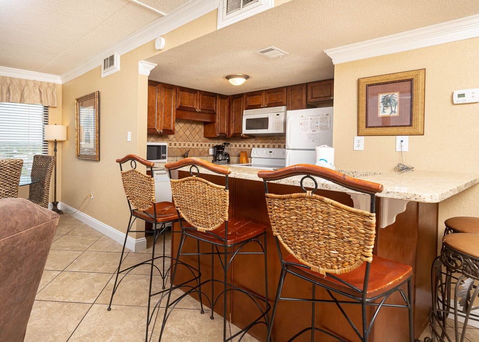 The kitchen features stylish cabinetry, modern appliances, and a cozy breakfast bar for a delightful cooking experience
