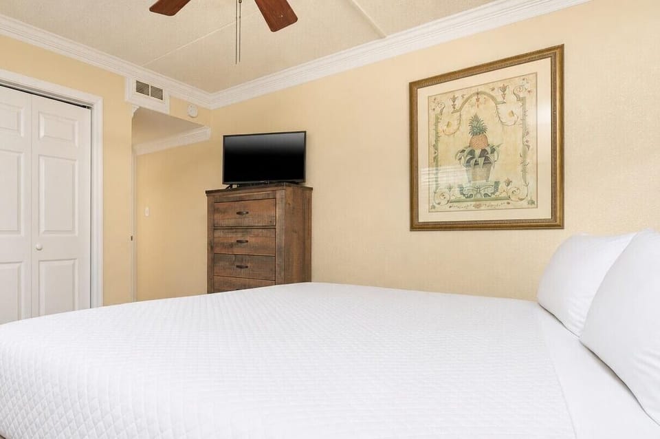 This guest suite features a cozy king bed, a stylish dresser, and a TV for relaxation