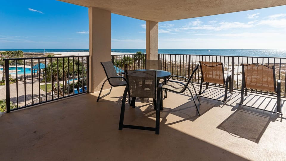 Enjoy relaxing moments on the spacious balcony with views of the sparkling water and nearby pool
